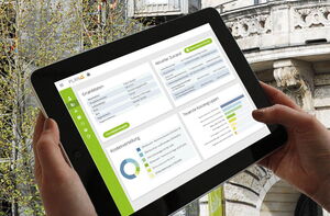 Tablet mit der GebäudeCheck App und im Hintergrund ein Gebäude
