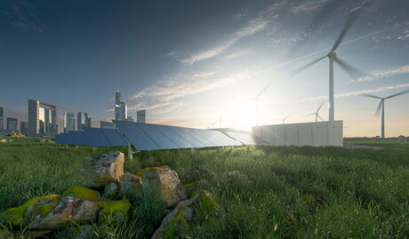 Grüne Wiese mit Solar und Windräder und einer Stadt im Hintergrund