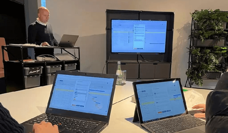 Eine Person, die vor einem Laptop steht und eine Schulung hält.