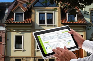 Tablet mit GebäudeCheck vor einem Gebäude